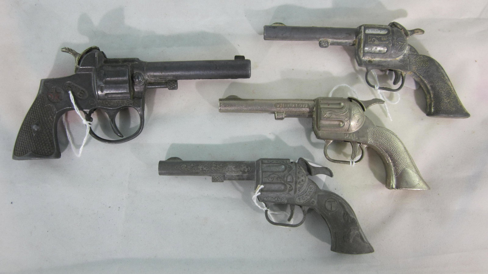 Hubley Cap Gun Assortment: 4 Hubley single shot capguns. 1 "Hub" pistol circa 1935, 6 1/4" long with 3 western revolvers circa 1955, "Pal", Texas" and another. Condition very good to fair, "Texas" firing mechanism broken. 4 pie