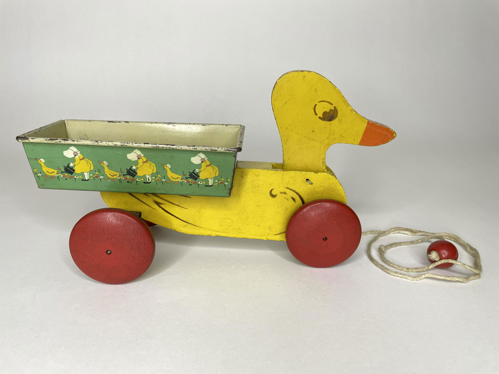 Duck Cart: Hustler Toy Corporation. Sterling, Illinois. Circa 1960s. Illustrates girl watering goose's tail. Wood and tin. 9 1/2 inches long by 5 1/2 inches high. Fine Condition.