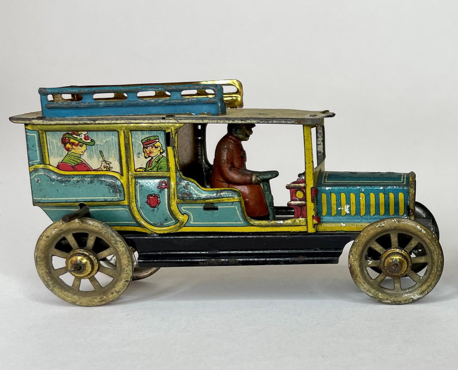 Penny Toy Limousine with Driver and Passengers: Made in Germany. Circa 1920. Flywheel. 4 1/2 inches long. Excellent Condition.