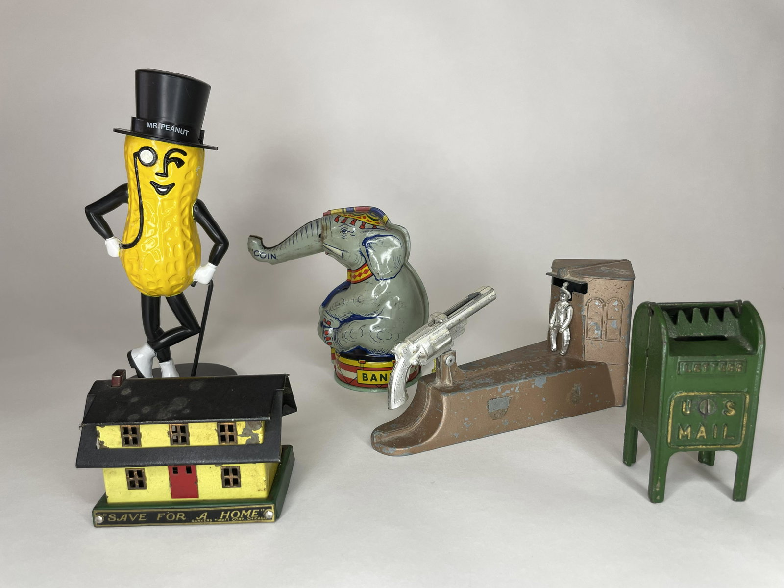 Lot of Assorted Banks: Including Chein Seated Elephant with Moveable Trunk, Wild West Bank (missing trap), US Mailbox (missing door and ship to top), Mr. Peanut and Save for a Home. 5 Pieces. Tin, cast iron, white metal and