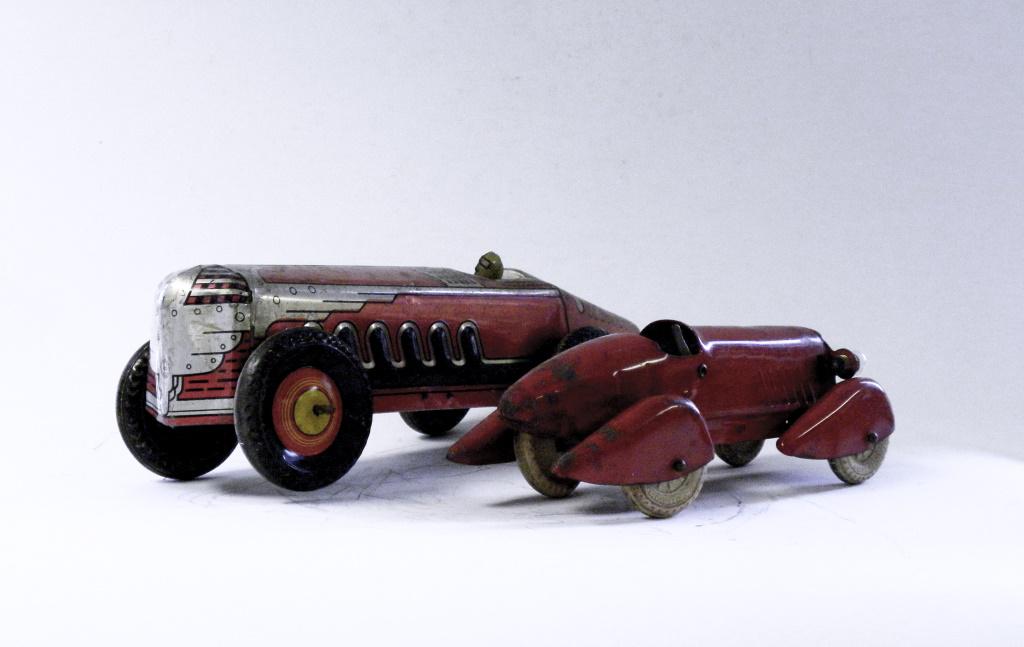 Two Race Car Tin Toys: Wyandotte / Marx. American - 1930's - 8 1/2" / 13" Long. The Marx is missing its mechanism and the front left tire is loose. The Wyandotte has working headlights.