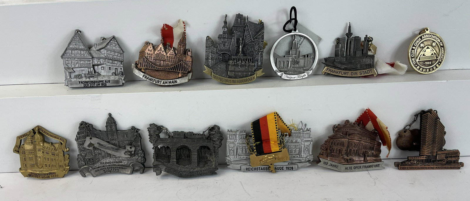Approximately 35 - 40 Souvenirs: Pins and Keychains. American / European - 1930's to 1990's - 1 1/2" to 4". Very Fine Condition.