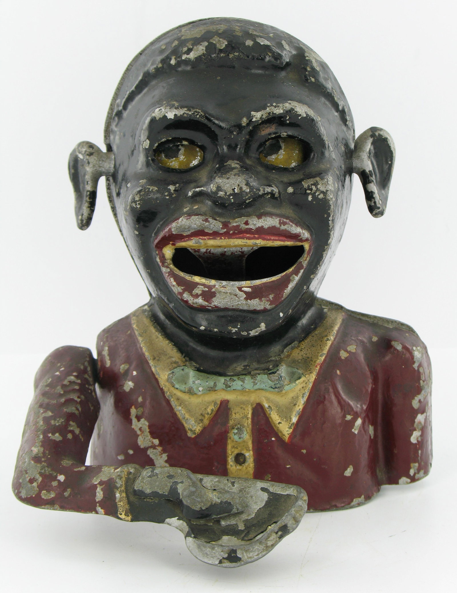 Jolly Man Sonny Boy Mechanical Bank: Made by Robert Starkies. Aluminum. Circa 1945. Uncommon dark red color. Eyes move down, raised chevrons on arm with lattice base. Lattice embossed "Starkies Patent 32587 and Registered Number 844290".
