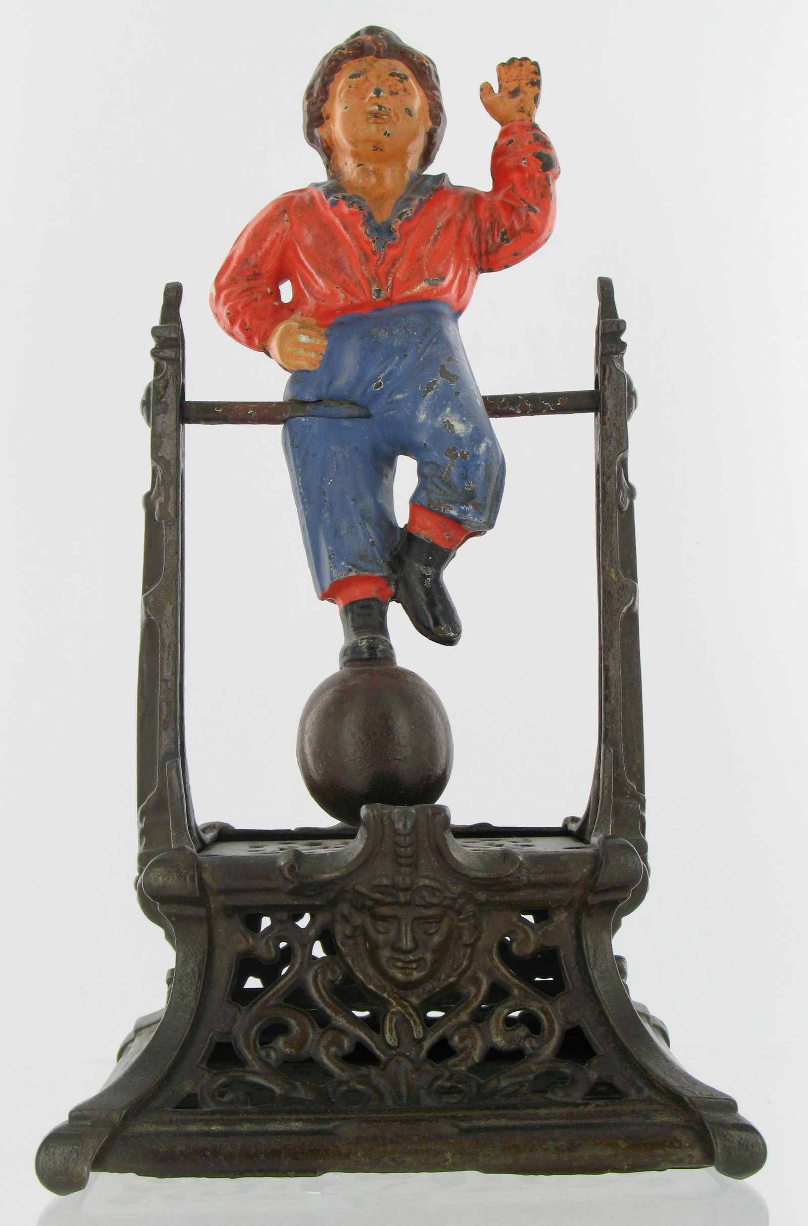 Boy on Trapeze Mechanical Bank: Made by the J. Barton Smith Company. Philadelphia, Pennsylvania. Circa 1890. Cast Iron. Excellent Condition.