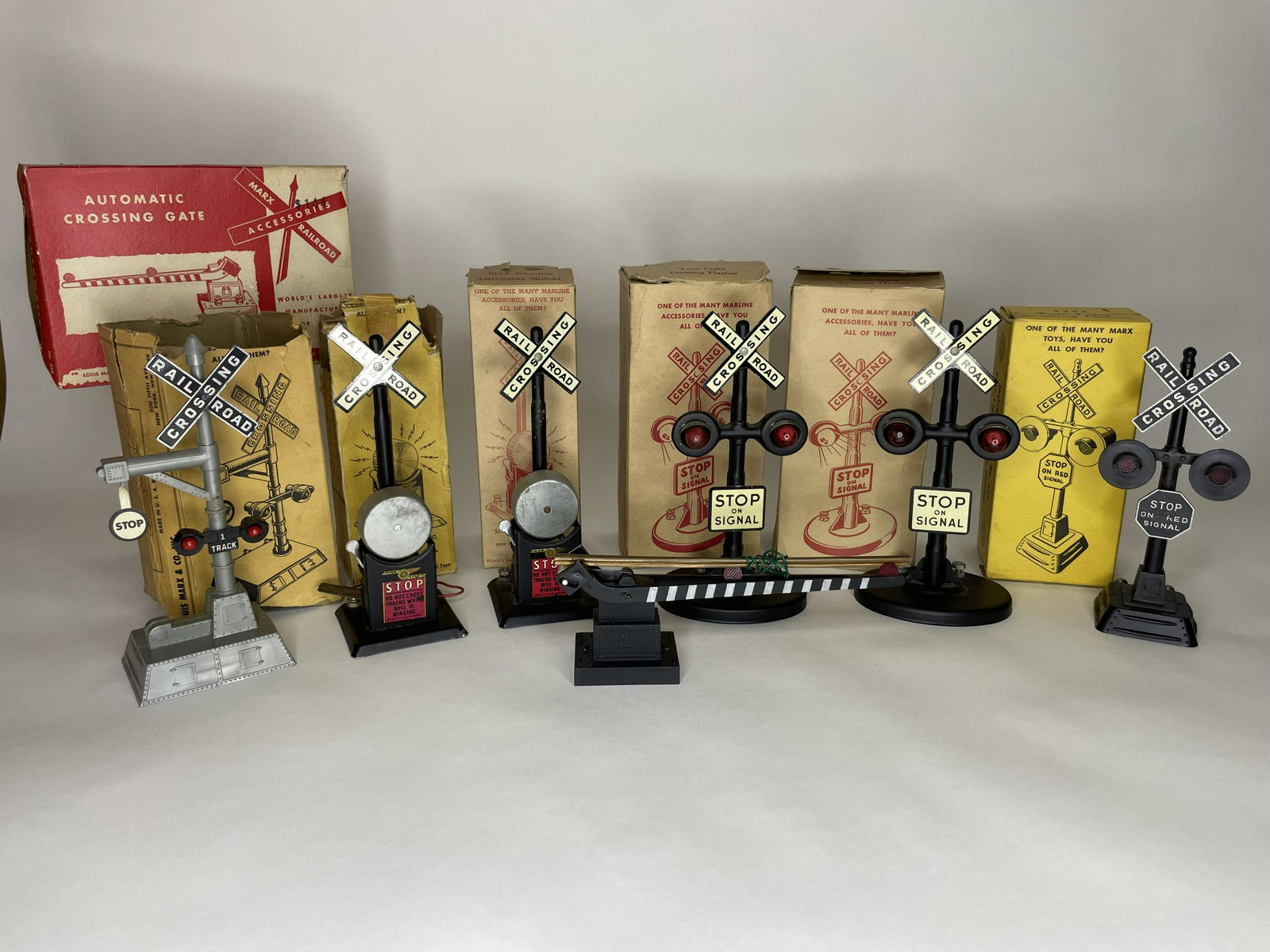 Lot of Railway Accesories: Two bell ringing crossing signals, two twin light flashers, crossing stop signal and automatic crossing gate. 7 Pieces. Most in original box. Very Good Condition. **Additional shipping due to large lo