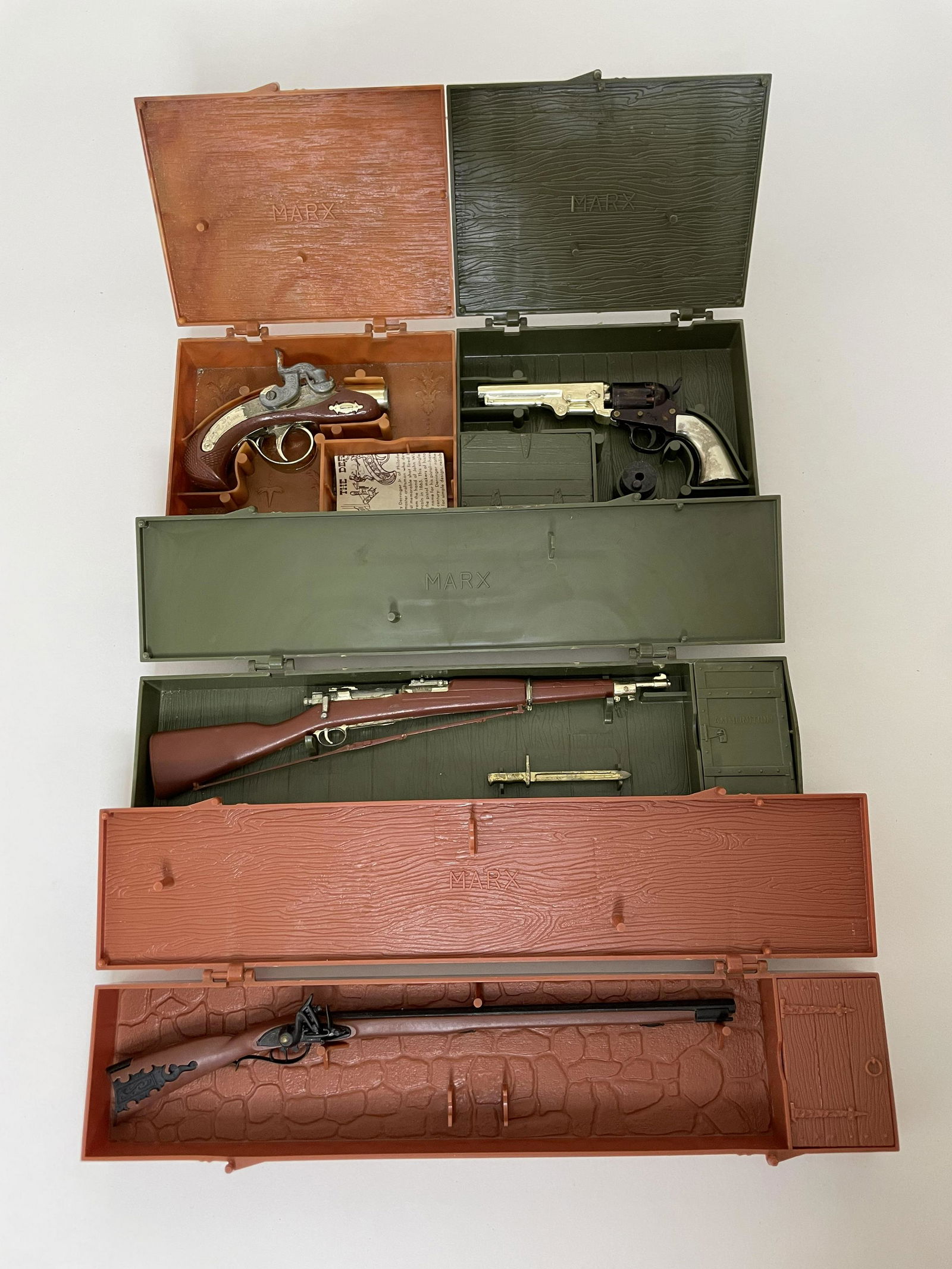 Lot Marx Miniature Toy Pistols and Guns: Including Stage Coach Pistol, The Darringer, The Springfield Rifle Model 1903 and the Kentucky Rifle. All in original plastic cases. 4 Pieces. Very Good Condition.