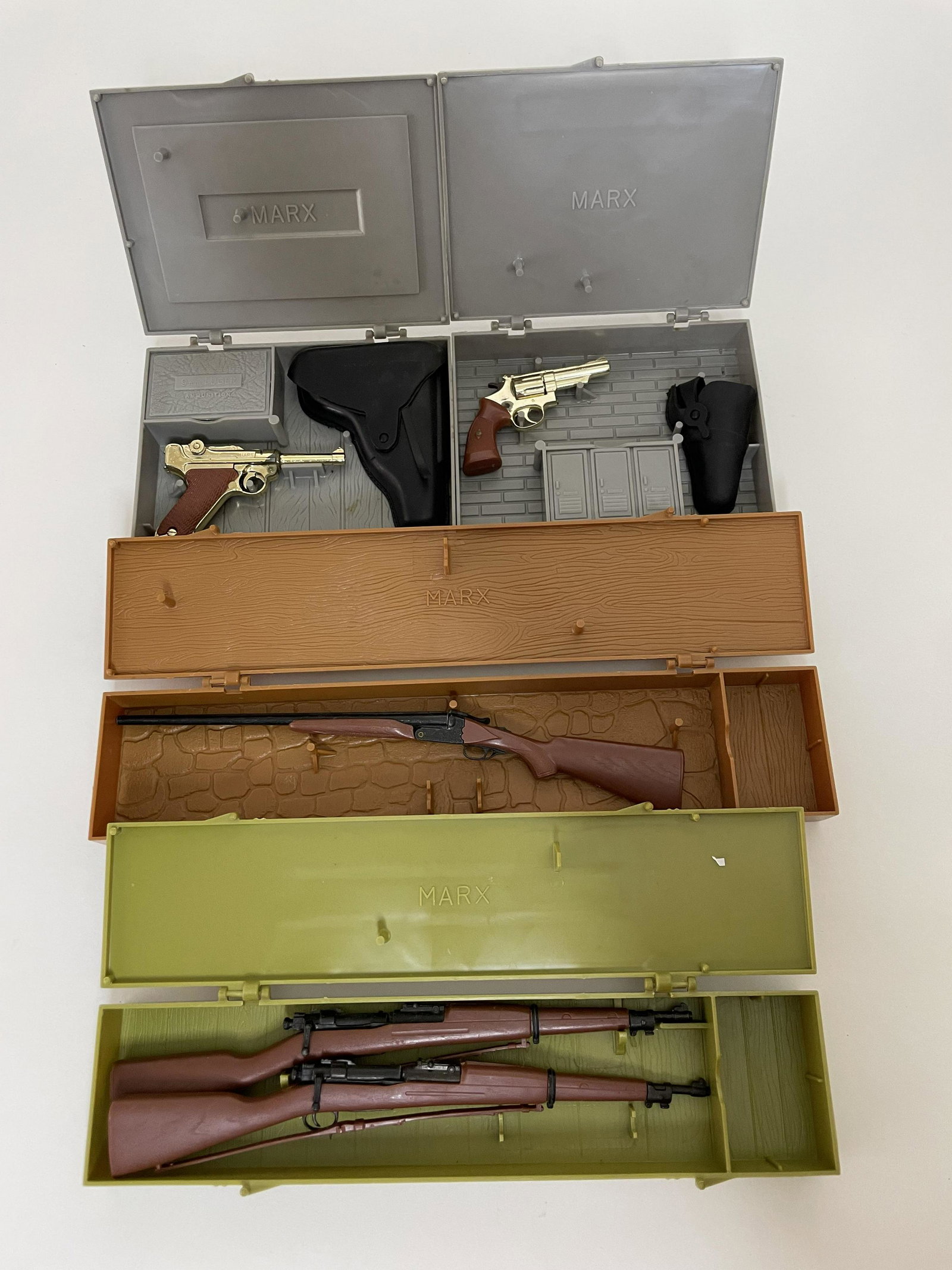 Lot Marx Miniature Toy Pistols and Guns: Including 9mm Luger, 357 Magnum, The Double Barrel Shotgun, The Springfield Rifle Model 1903 and the Kentucky Rifle. All in original plastic cases. 4 Pieces. Very Good Condition.