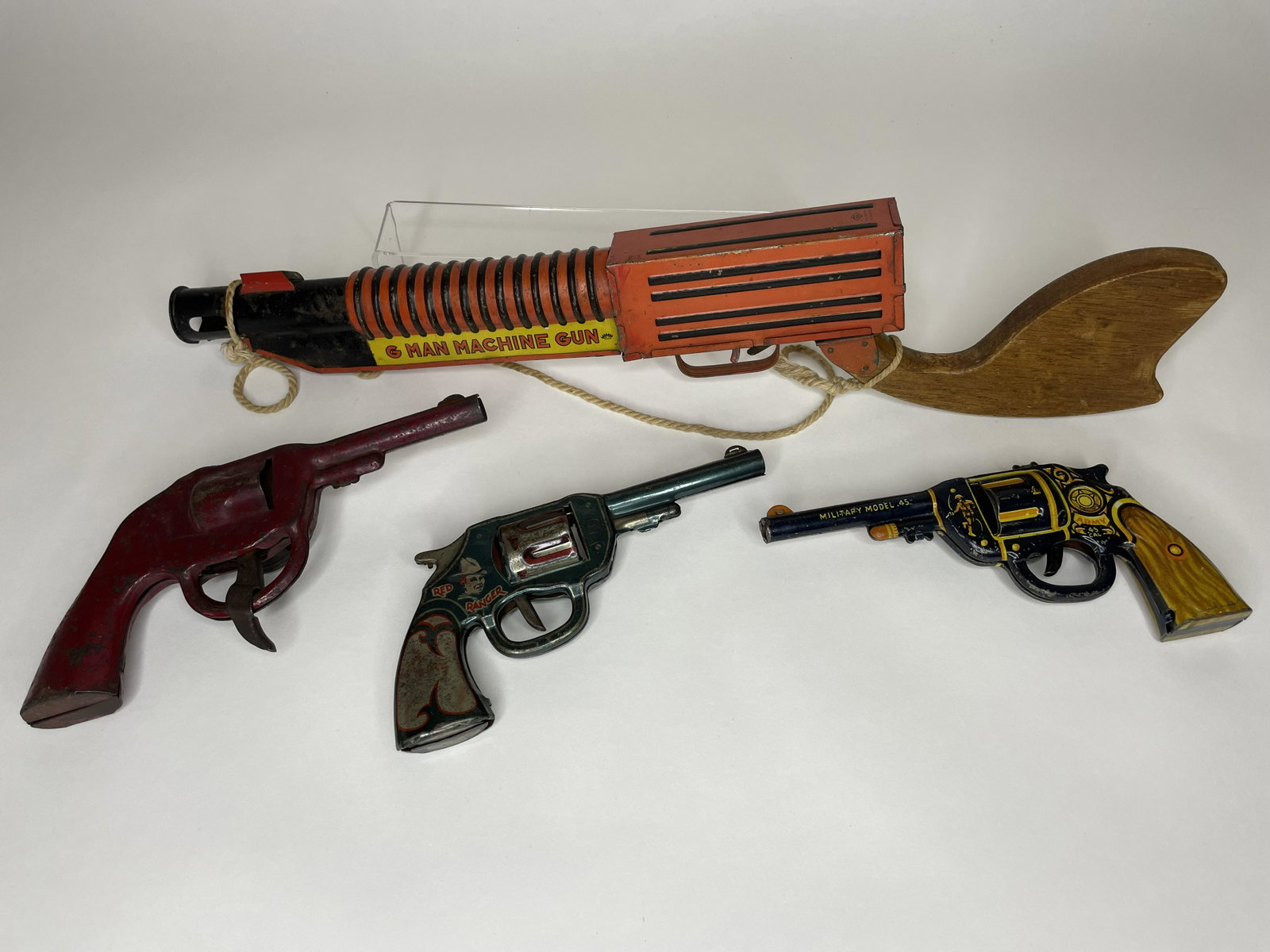 Lot of Tin Pistols: Including Army Military Pistol, G-man Machine Gun, Red Ranger and Friction Sparker. Good Condition.