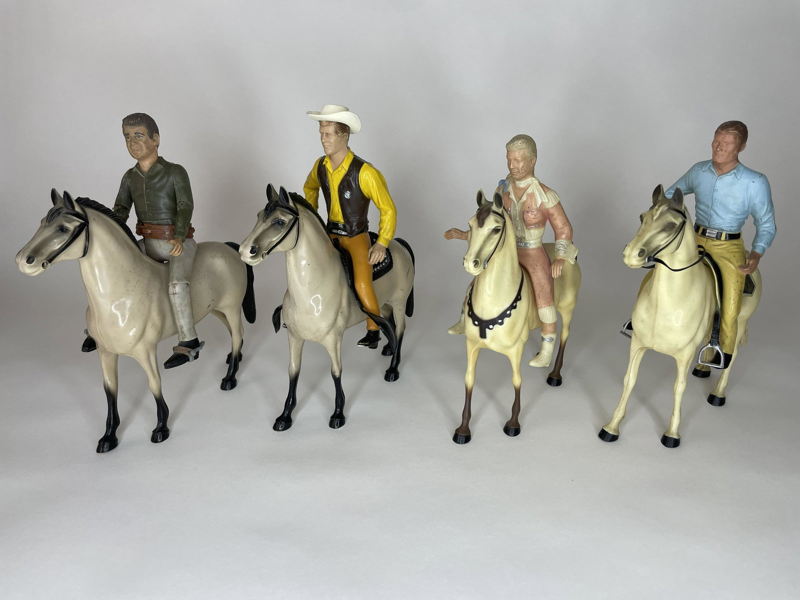 Lot of 4 Hartland Cowboys on Horses: Including Matt Dillon from the TV show Gun Smoke, Annie Oakley, and The Rifleman. 9 1/4 inches high. 4 Pieces. Good Condition; Missing a variety of accesories.