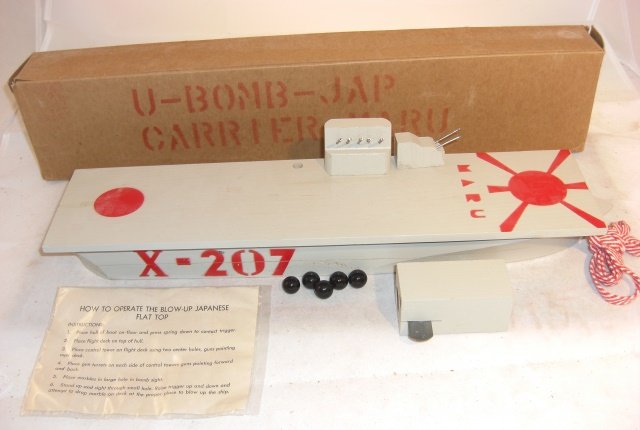 U-BOMB JAP CARRIER - MARU: Wood carrier 18" long in box; pieces come off when "bombs" (black marbles) are dropped through a hand-held "bomb site"; includes gun missing from picture, all pieces present; mechanism works; conditio