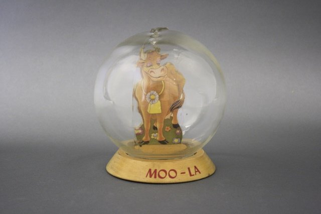 "Moo-La" Bubble Bank: "Moo-La" Bubble Bank (6 1/4" H). Made of wood/glass/cardboard and in pristine condition. Manufactured by Vic Moran of the United States circa 1930.