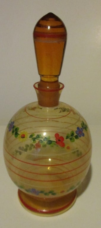 Amber Enameled Decanter: Amber Glass Enameled Decanter Decorated with enamel red, blue and yellow flowers hand painted. Type: Decanters Dimensions: H 9" Condition Report No