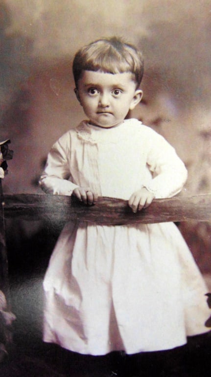 Portrait of a Starring Boy by David Lathrop: Portrait of a Starring Boy by David Lathrop A young boy with wide open starring eyes and skirt at the fence. Photographer: Attrib: David Lothrop Dated: C1900 Subject: Portraits - Children Medium:
