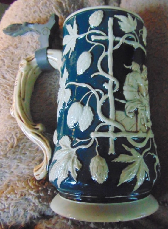 German Mug with Scene and Foliage: German Mug with Scene and Foliage Very nice design. See photos. Origin: Germany Date/Period: Between 1890 & 1918 Type: Stoneware Dimensions