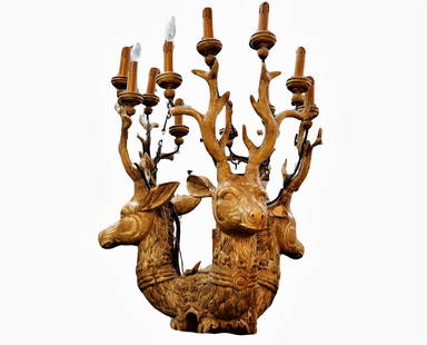 19th Century Carved Wood Stag Head Chandelier: Antique 19th Century carved wood 3 stag head chandelier with lights at the tops of the horns. 12 lights in total. 48.5" drop with a 26.25" diameter