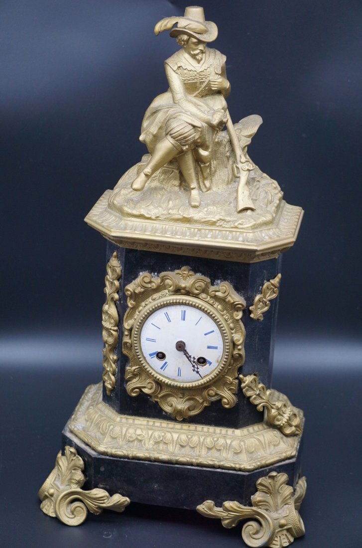 Don Quixote Bronze and Wood Clock: Antique painted black wood and Dore bronze clock with a porcelain painted blue face and Don Quixote depicted on top. Measures 19" tall with a 10" base and 6" depth