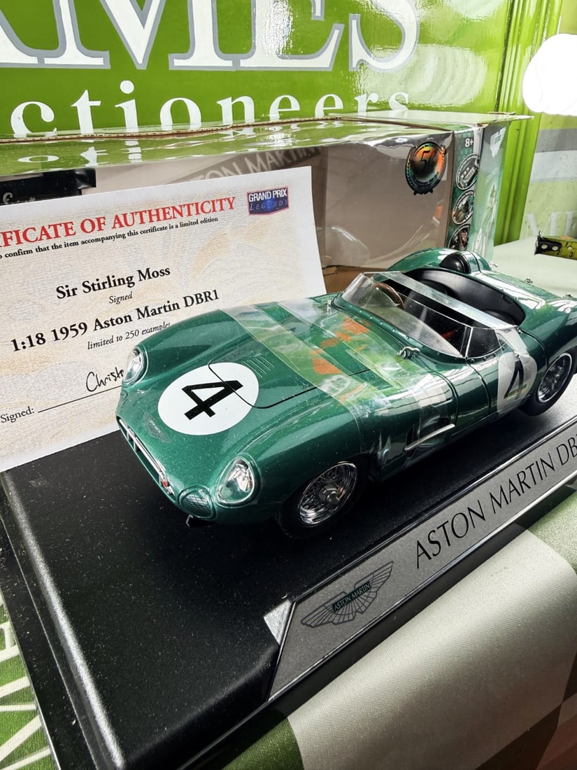 Ltd Edition 1:18 Scale Aston Martin DBR1, by Shelby Collectibles, Signed by Sir Stirling Moss: A limited edition 1:18 scale Aston Martin DBR1 model car, by Shelby Collectibles, the tonneau cover signed by Stirling Moss, with CoA, boxed
