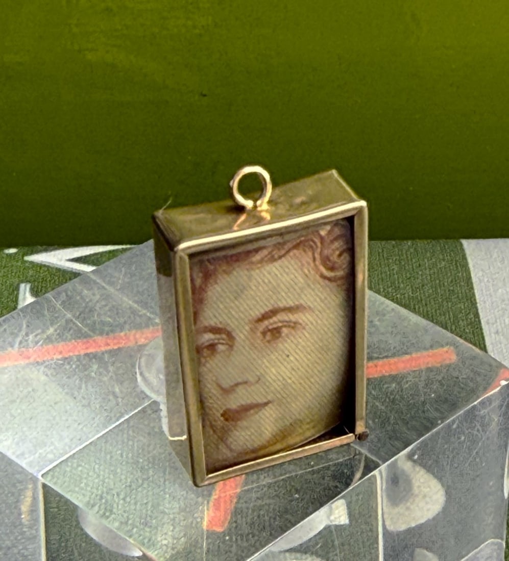 A Rectangular Ten Shilling Banknote Charm, Mount Hallmarked 9ct Gold, London: A Rectangular Ten Shilling Banknote Charm, Mount Hallmarked 9ct Gold, London, Ten Shilling Note with Queen Elizabeth. approximate dimensions length 24.2mm x width 20.2mm