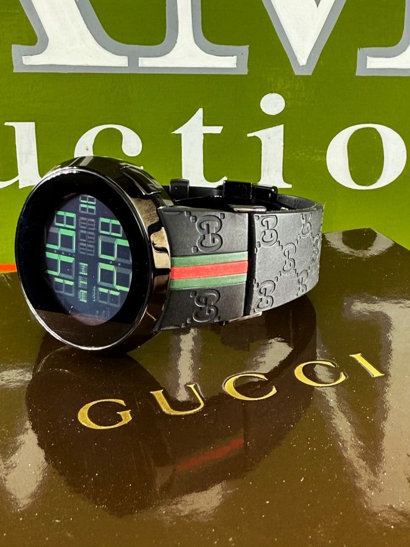 Gucci Vintage 114-2 Digital-Monogram Gucci Original Belt Edition: Gucci - 114-2 Stainless steel case. Quartz movement. LCD digital display dial. On a signed black rubber strap with stainless steel deployant clasp.black gucci monogram design.tested as working at