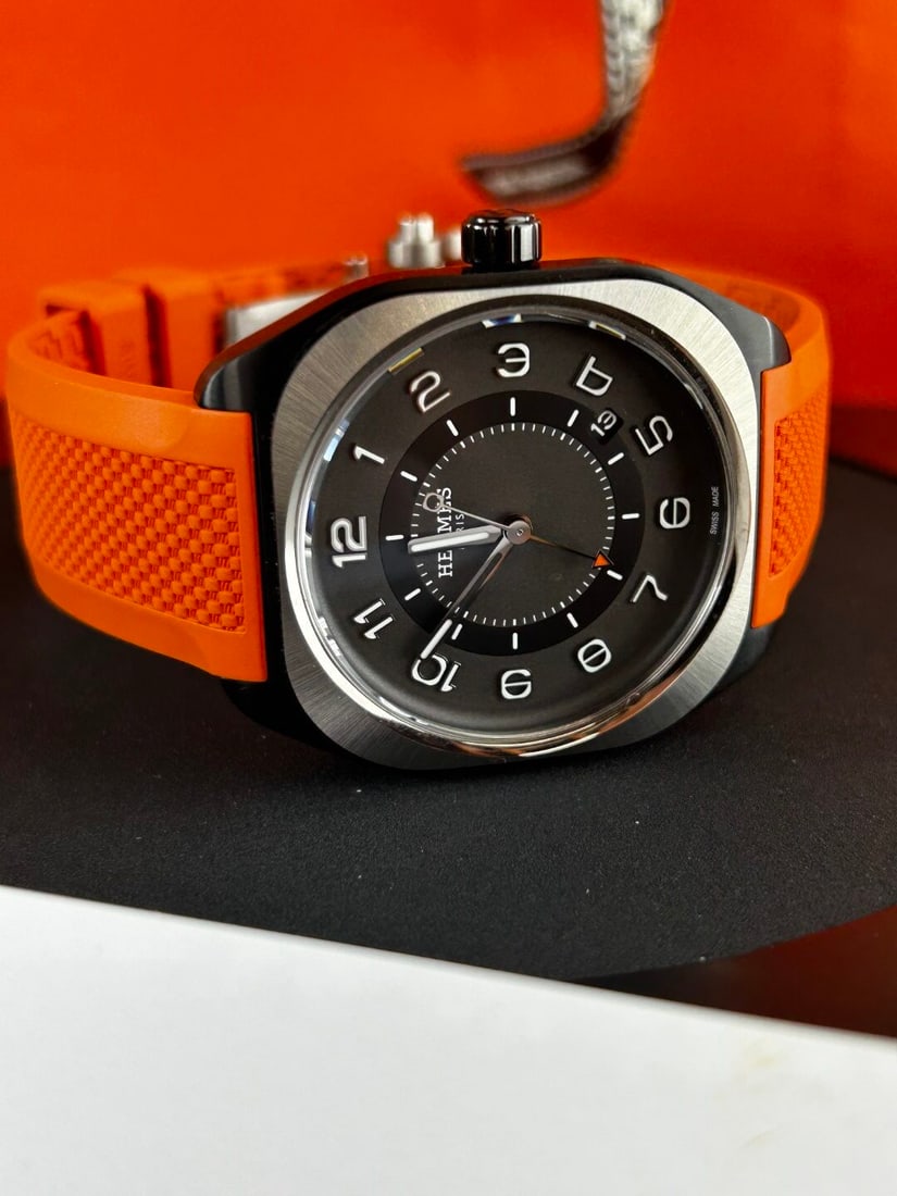 Herms Paris Mens H08 SP1.741a Titanium Edition RRp GBP 6k: The Hermès H08 (Ref. SP1.741a) is a modern, sporty-chic men's watch featuring a 39mm x 39mm (or 42mm depending on version) cushion-shaped titanium case with a satin-brushed finish and black DLC