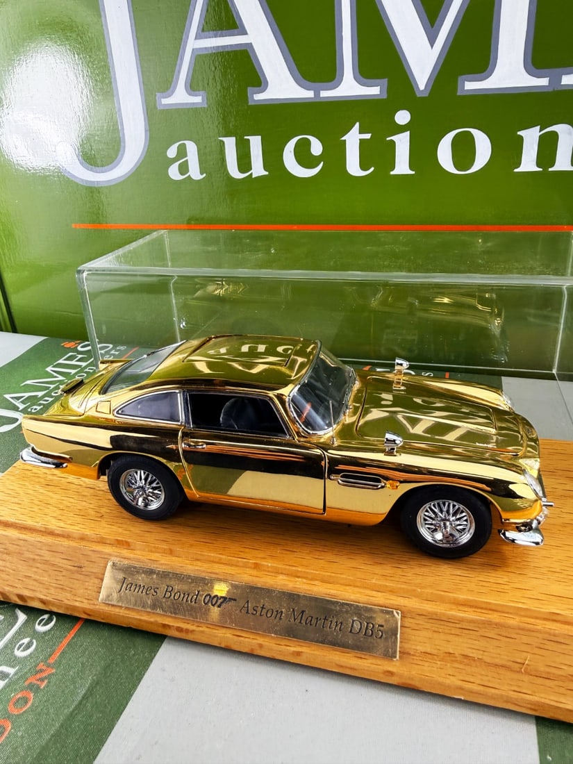 James Bond 007 Danbury Mint Aston Martin-Gold Plated 24k Edition: James Bond 007 Danbury Mint Aston Martin-Gold Plated 24k Edition, as pictured with plinth and perspex case. Unchecked example. All parts present.