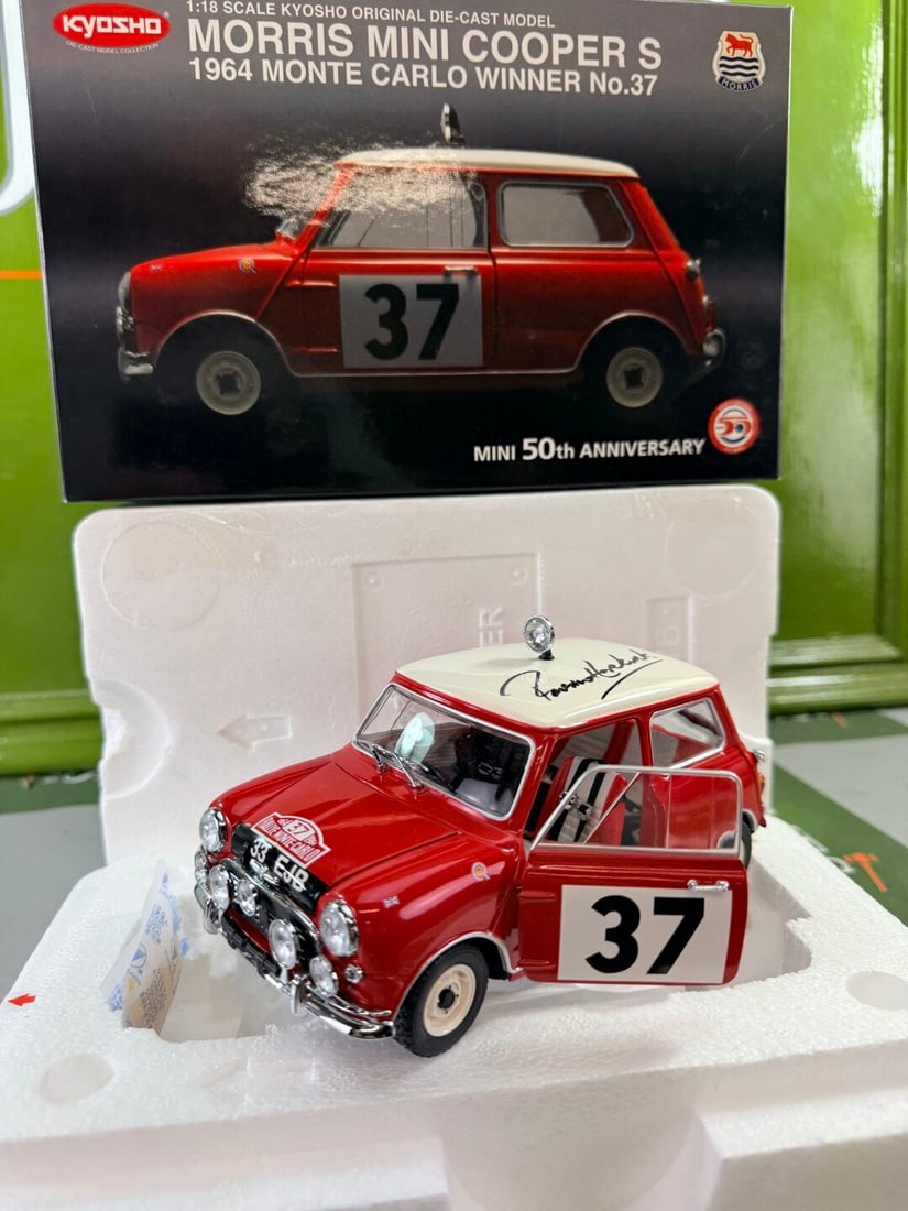 1/18 scale Morris Mini Cooper S 1964 Monte Carlo Winner 50th Anniversary signed by Paddy Hopkirk: Kyosho 1/18 scale Morris Mini Cooper S 1964 Monte Carlo Winner (No. 37) 50th Anniversary signed by Paddy Hopkirk, housed in a polystyrene-packed pictorial card box