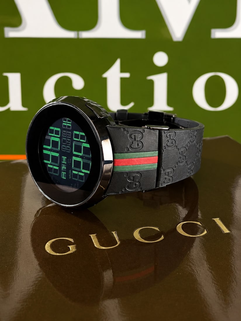 Gucci Vintage 114-2 Digital-Monogram Gucci Original Belt Edition: Gucci - 114-2 Stainless steel case. Quartz movement. LCD digital display dial. On a signed black rubber strap with stainless steel deployant clasp.black gucci monogram design.tested as working at time
