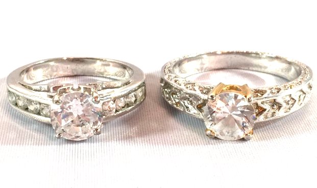 2 Ladies Sterling Silver Solitaire Fashionista Rings: Lot of 2 ladies fashion rings: silver filigree band with large solitaire stone (size 10.5) and ladies silver tone band with large round brilliant cut solitaire and channel set 4 small brilliant stones