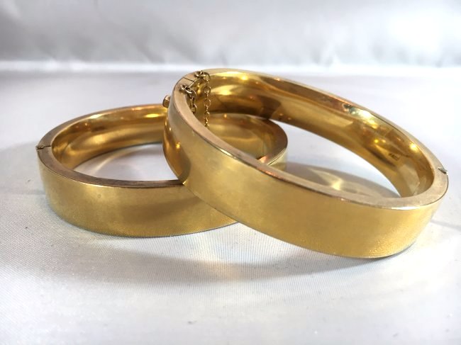 12K Gold Filled pair of Ladies Bangle Bracelets: 2 ladies matching bracelets with hinged side and safety chain. Marked 12K Gold Filled.