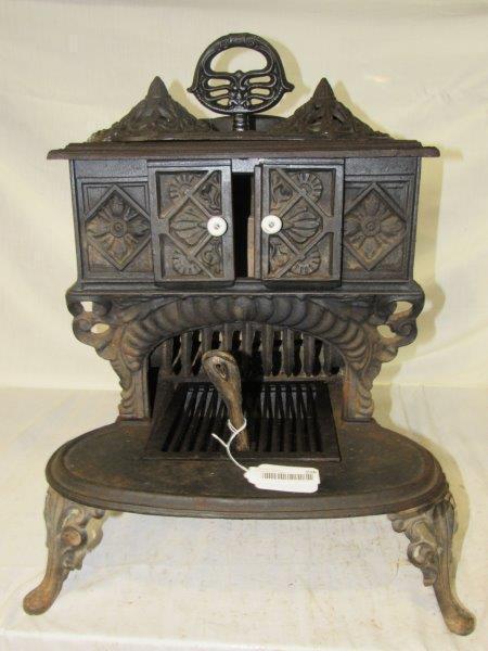 Small ornate cast-iron stove: Very ornate stove with burners on top, the ornate burner covers can be removed. Approximately 17 1/2 in wide 17 in deep 20 in tall