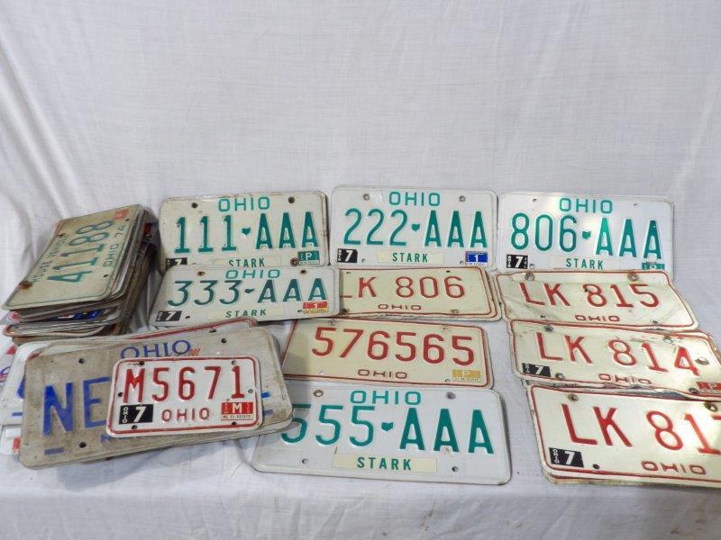 Approximately 60 Ohio license plates: Mostly modern plates with some denting.