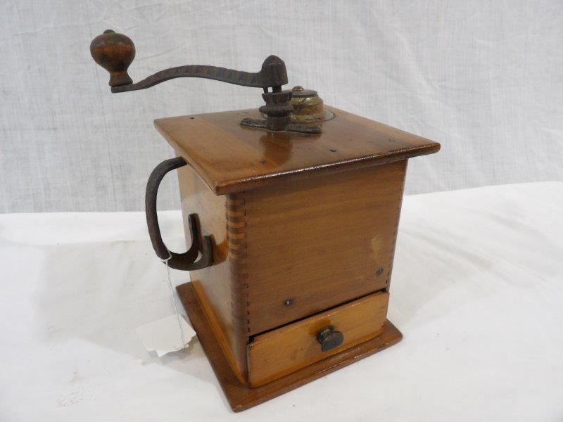 Primitive dovetailed coffee mill: Ornate carrying handle on side and grinding crank. 6 1/2 in wide 6 1/2 in deep 7 1/2 in tall.