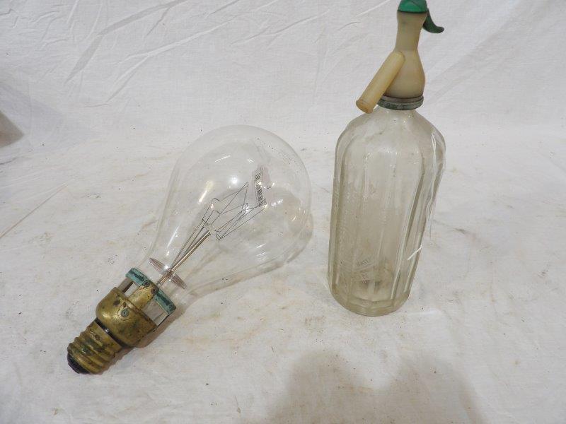 1930s Seltzer bottle and 1920s light bulb: Fluted bottle is marked S. Rallen & Sons and is 12 in tall. Green plastic tip on top of bottle has a crack . Large early light bulb appears to be in good condition and is 12 in Long