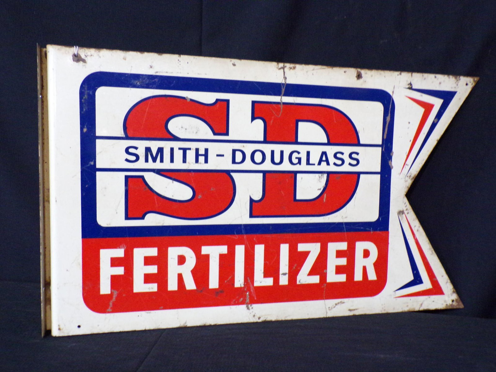 DST Smith Douglass fertilizer flange sign: with heavy corrosion spotting throughout sign on both sides but has great colors and still has some gloss. 12 inches x 21in.