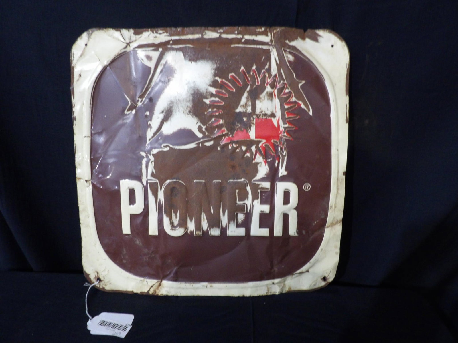 SST Pioneer embossed sign: with heavy wrinkles and paint loss in field. Is marked Stout sign. 18 in x 18 in.