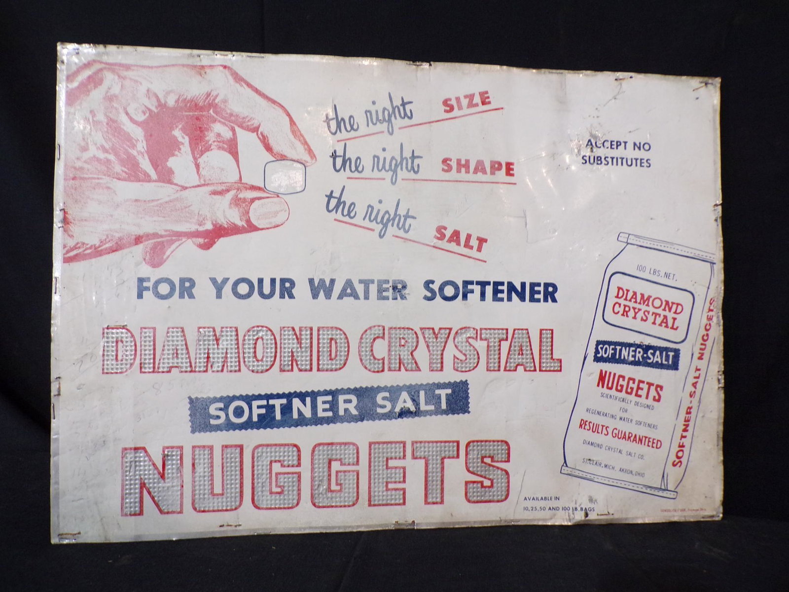 SS TIN DIAMOND CRYSTAL SALT CO. ON WOOD BACKER SIGN: 14" H x 20" W THIS IS A VERY THIN SHEET OF TIN STAPLED TO A WOOD BACKER AND SHOWS CRIMPING AND HOLES TO EDGES AS WELL AS NUMERICAL WRITING ON SURFACE OF SIGN. CONSOLITE CORP. FREMONT, OHIO