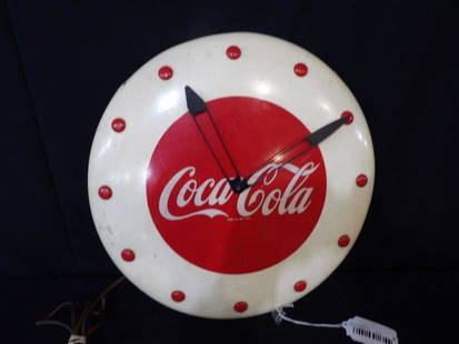 1948 Coca-Cola button clock: Metal electric clock that is in working condition. Shows minor wear and patina but overall is pretty nice! Has something added on back. 16 in diameter