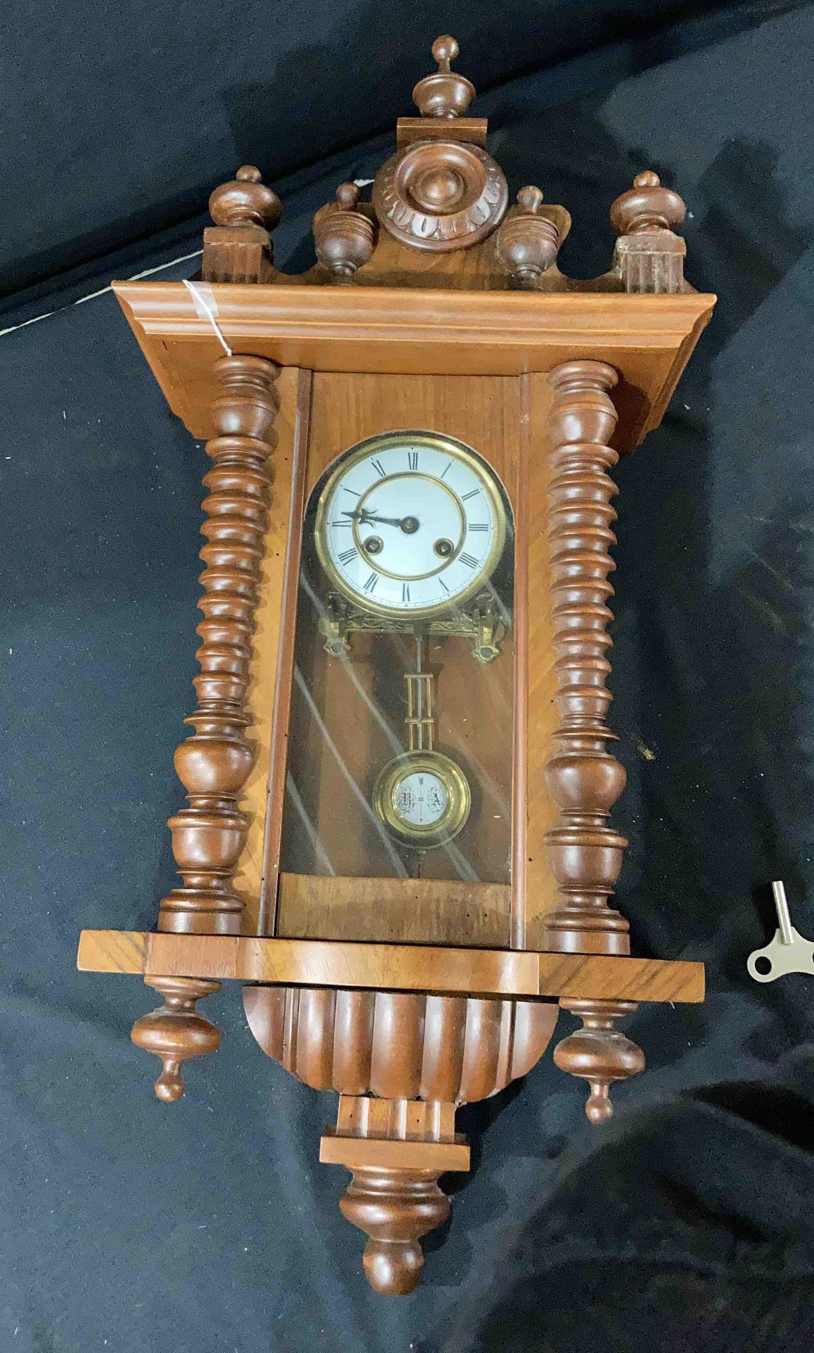 Wall clock: Clock is in good condition but needs some tlc. One hand is missing and the bottom wood finial has come loose. Unable to read makers mark.