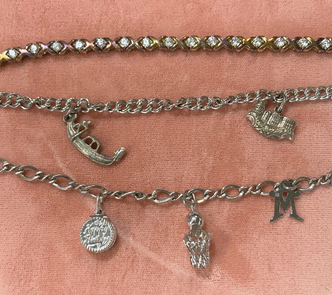 Sterling Silver Tennis & Charm Bracelets: .925 3ct gemstone tennis bracelet, .925 charm bracelet featuring a basketball hoop, birthday cake, and M, .925 charm bracelet featuring a Heidenberg and gondola charms.