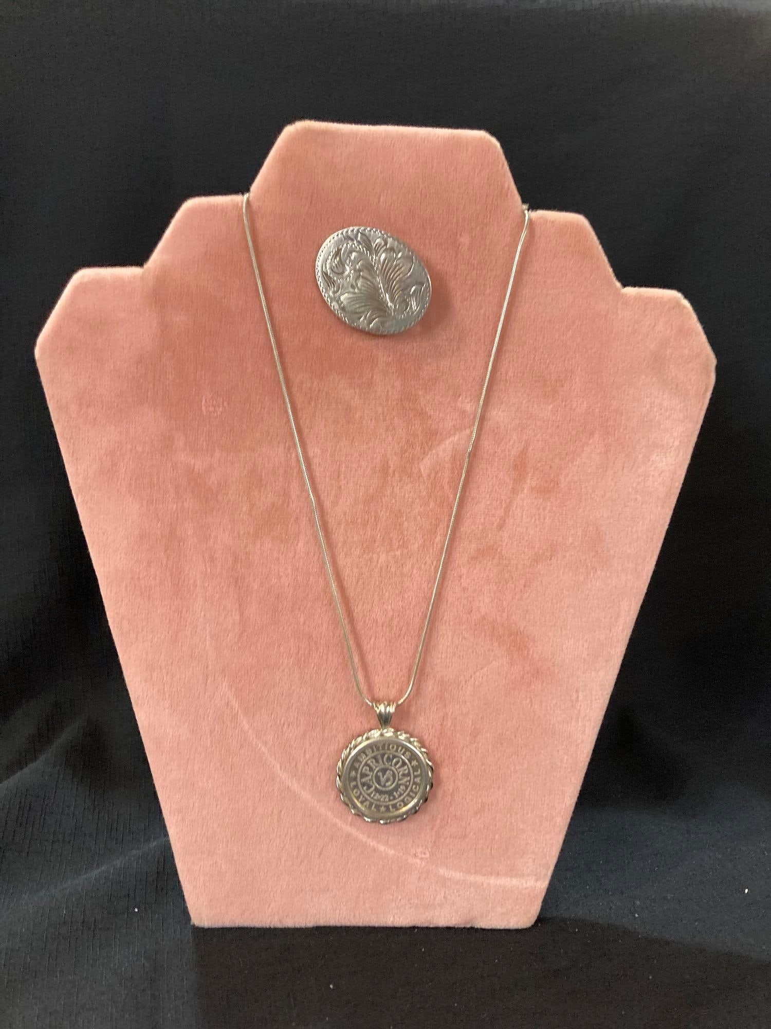 Sterling Silver Capricorn Pendant & Chain and Floral Brooch: .925 1/4oz 999 silver Capricorn charm with .925 16'' snake chain, .925 hand etched vintage brooch.