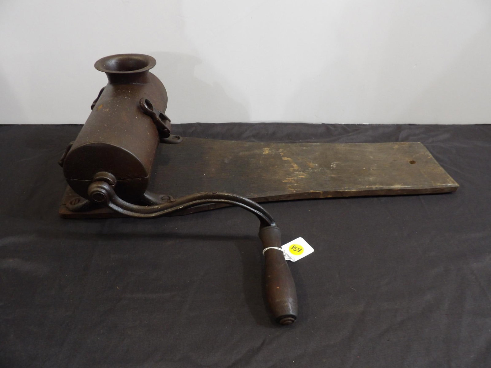 MOUNTED TOBACCO GRINDER: BOARD IS 23 INCHES LONG. HANDLE TURNS SMOOTHLY