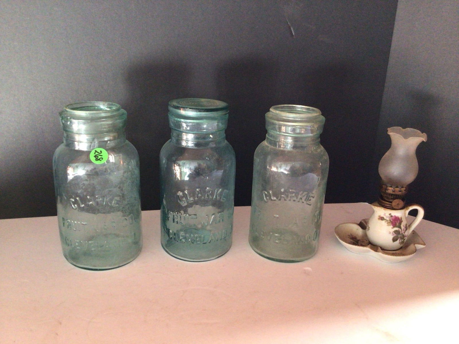 3-Clarke Fruit Jar Co. Cleveland, O jars: All Have minor wear on top rims. But no visible chips or cracks, 1 with lid. Also includes small kerosene lamp.
