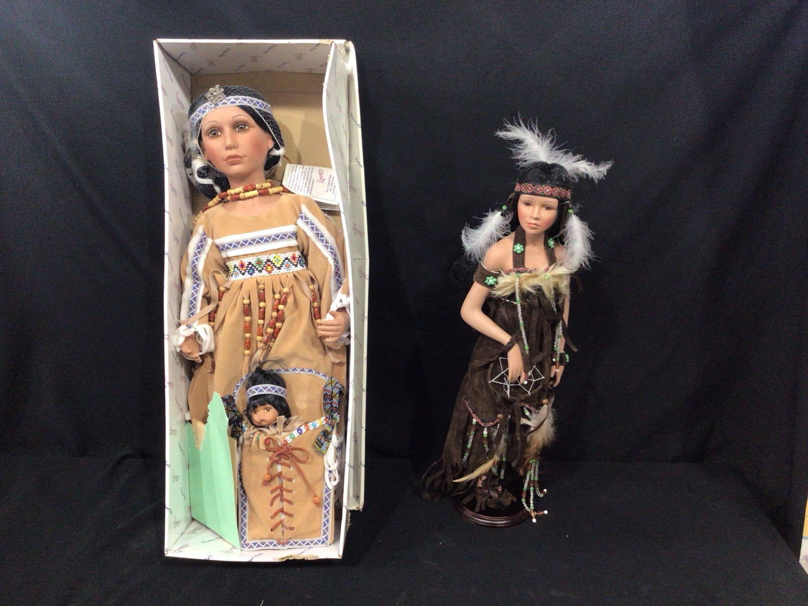 Native American Porcelain Dolls: One by the Duck house in original box with paperwork, both in very nice condition, with beadwork and leather dresses.