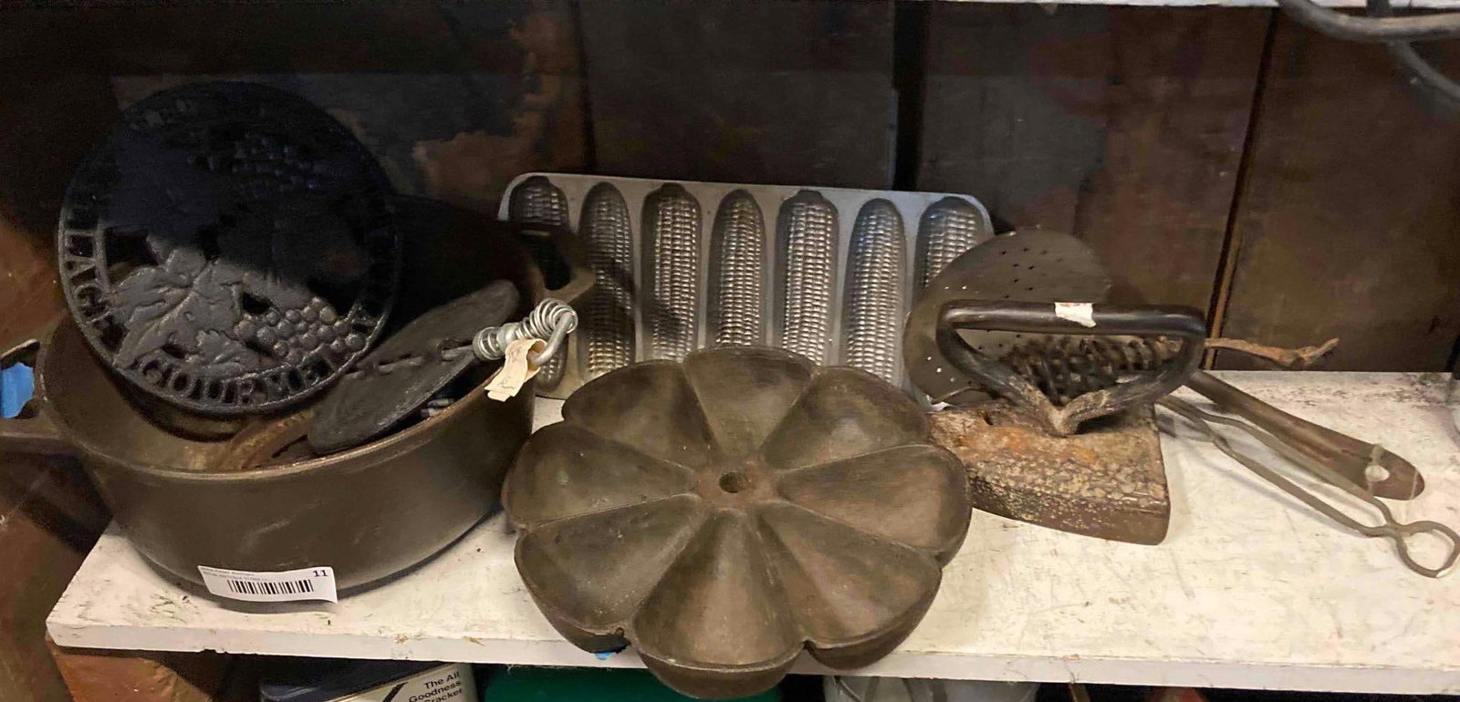 CAST IRON POT, TRIVETS, AND SORTING TRAY: INCLUDES SAD IRON, CORNBREAD PAN, UTENSILS AND MORE. CAST IRON POT HAS A CLEAN INTERIOR.