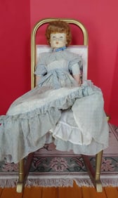 CHILDS METAL ROCKING CHAIR W/ UPHOLSTERED SEAT AND EARLY PORCELAIN DOLL