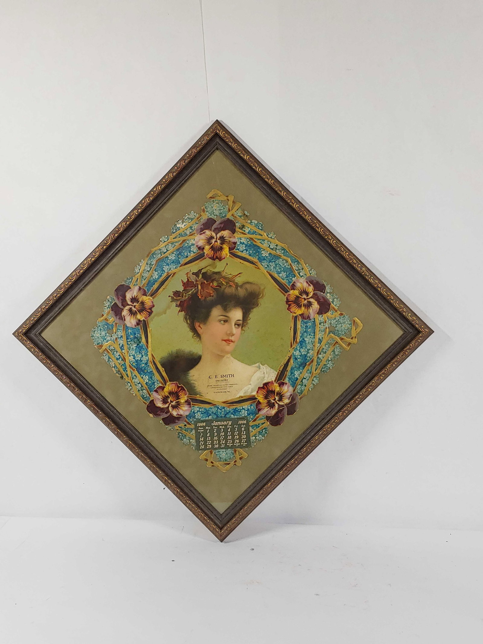 1906 C.E. Smith Druggist framed calendar: Calendar shows some condition with edge wear, a few small breaks and creases but with great graphics of early Madame. 20.5in x 20.5in.