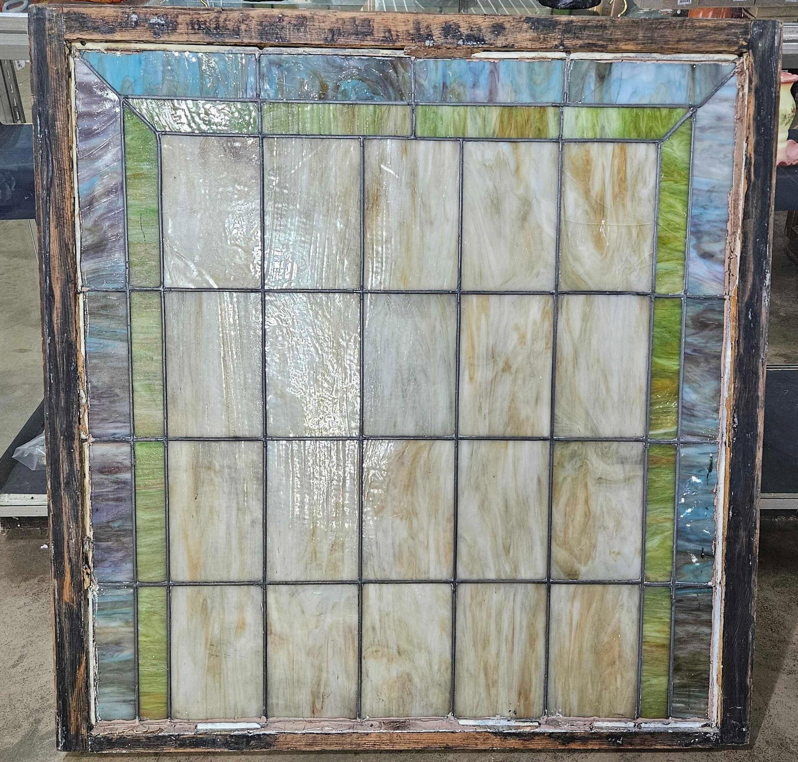 STAINED SLAG GLASS WINDOW: SEVERAL PANELS ARE CRACKED BUT NOT LOOSE AND HOLD TOGETHER NICELY. METAL STABILIZER BARS MOUNTED ON BACK. 39X41