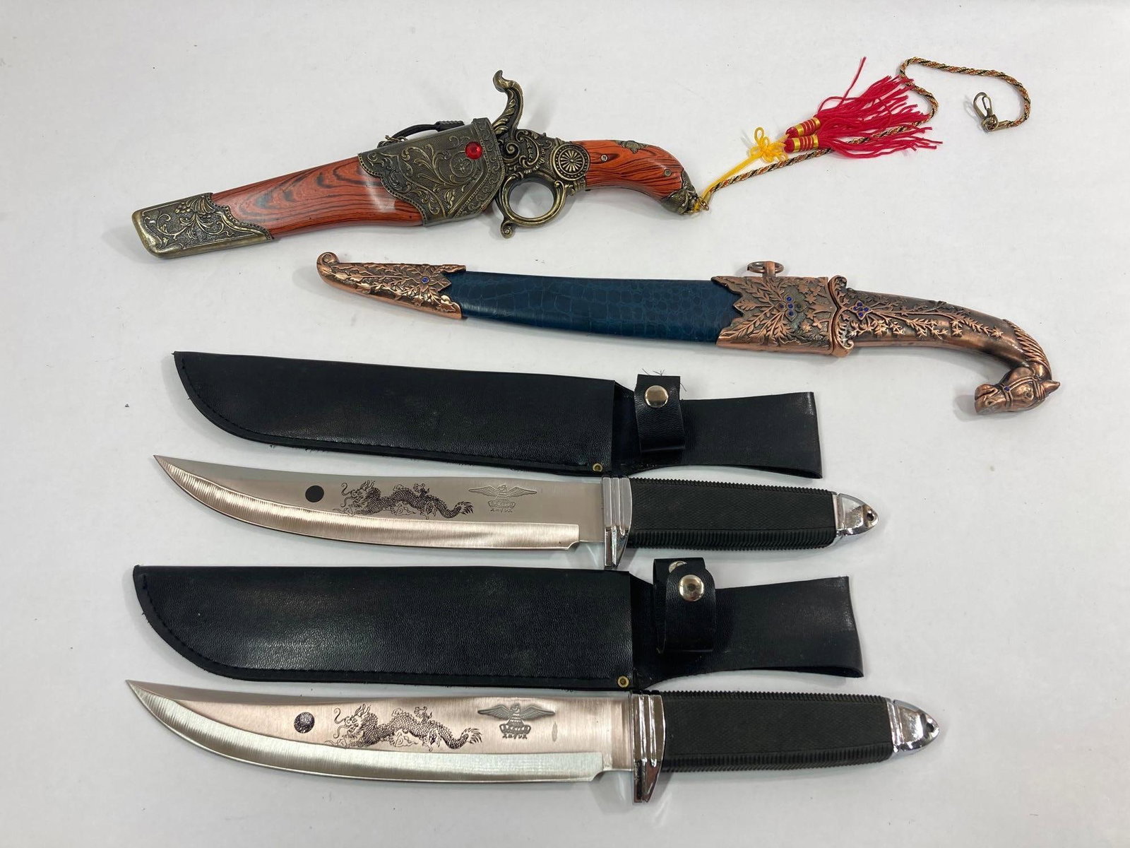 SEKIZO AND DECORATIVE KNIVES: 2 SEKIZO KNIVES WITH DRAGON ETCHED BLADES, 9 IN BLADE WITH 14 IN HANDLE EACH WITH LEATHER SHEATH. OTHER KNIVES FEATURE HORSE HEAD AND PISTOL SHAPED.