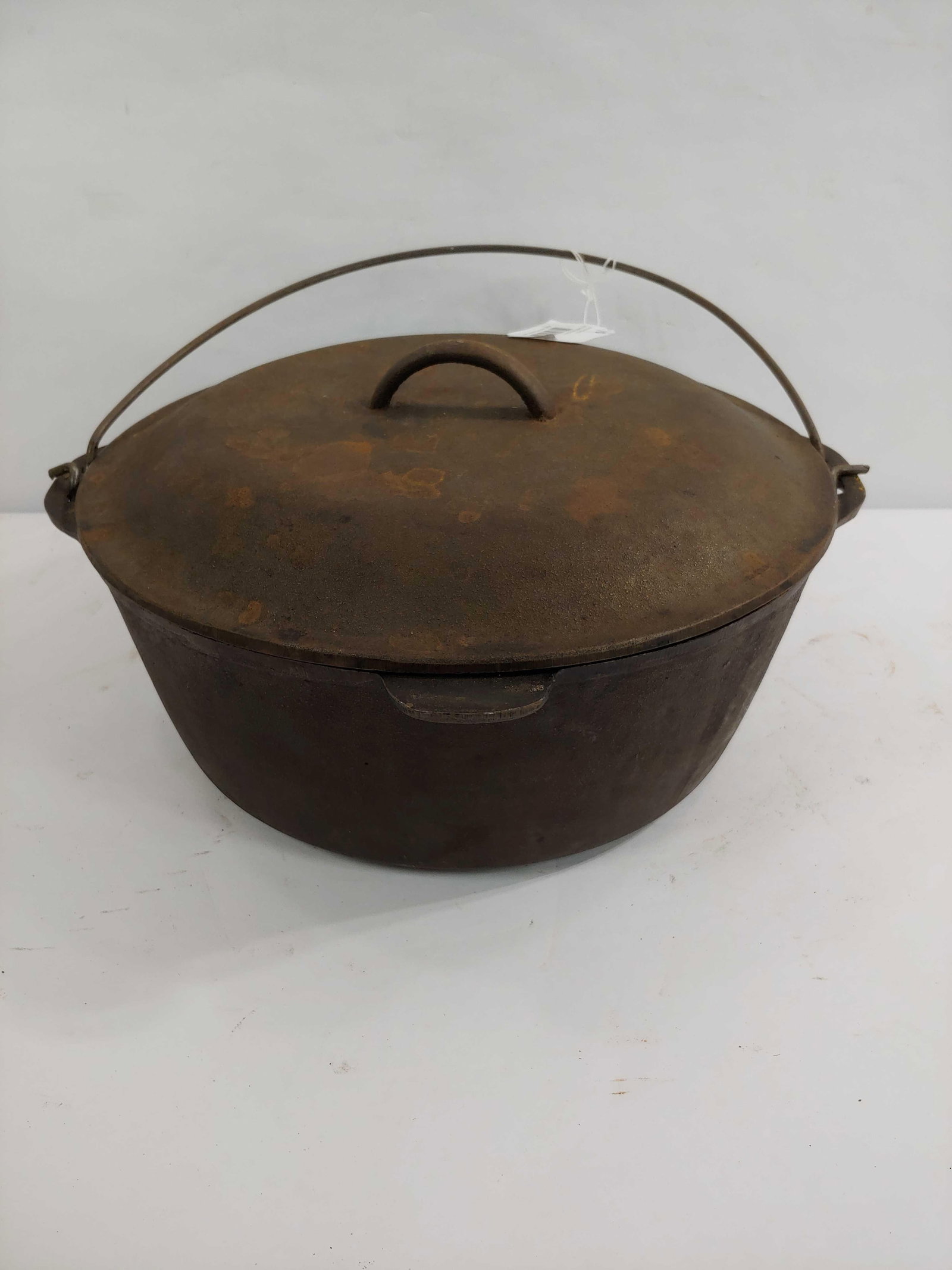 CAST IRON #10 DUTCH OVEN: SELF BASTING LID AND HEAT RING. INTERIOR OF POT SHOWS SOME SEDIMENT.