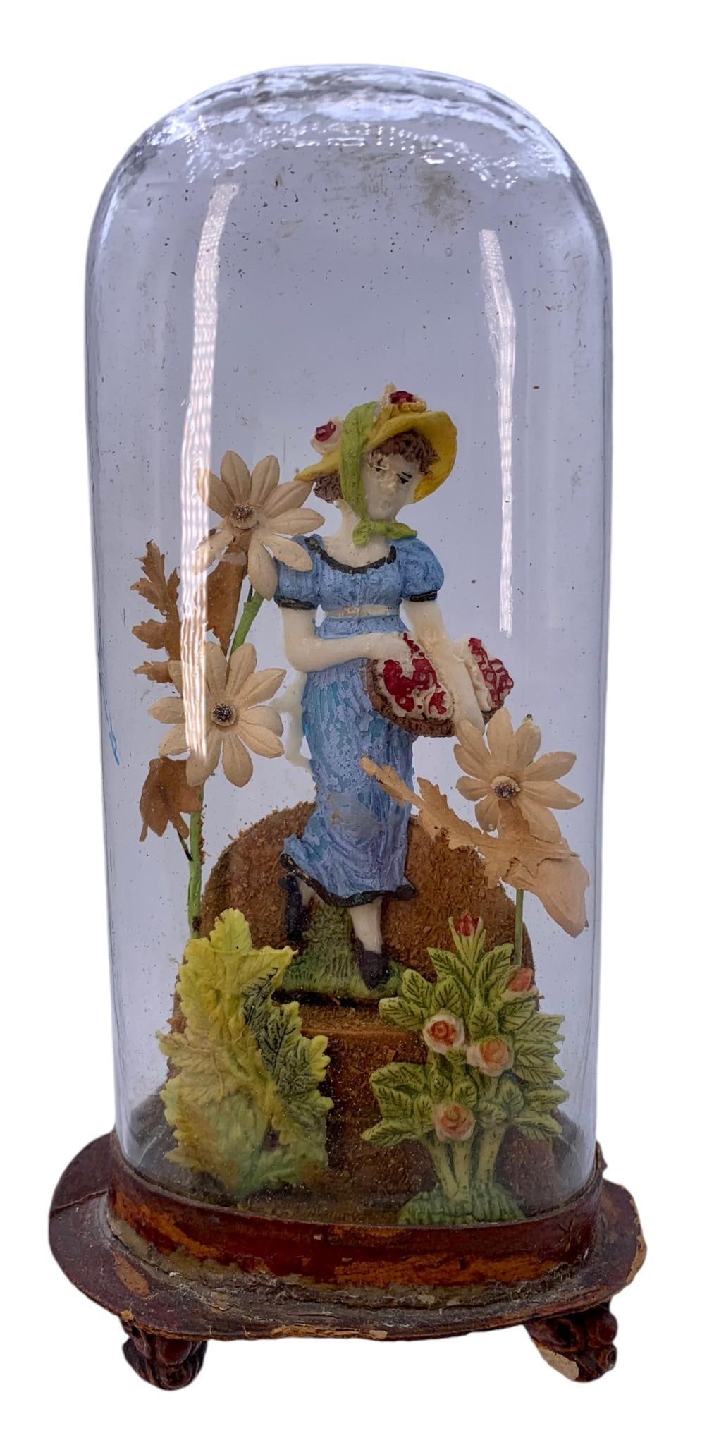Victorian Domed Glass Cloche Figural Wax Vignette: No breaks to the glass dome, age and wear to the paperboard base, wax/paper/sawdust composition, 8 5/8" x 4 1/2" x 3".